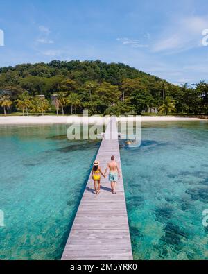 Ein Paar Mann und Frau auf einem Holzsteg auf einer tropischen Insel in Thailand, Koh Kham in der Nähe von Koh Mak Trat, einem hölzernen Pier auf einer tropischen Insel Stockfoto