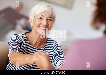 Sich geliebt zu fühlen... eine ältere Frau, die ihre Töchter an der Hand hält. Stockfoto