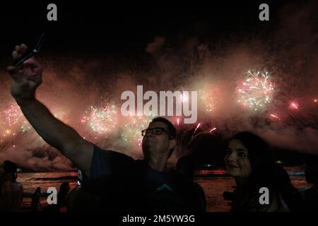 Rio De Janeiro, Brasilien. 01. Januar 2023. Am Silvesterabend sehen die Leute das Feuerwerk am Copacabana Beach. Kredit: Joao Gabriel Alves/dpa/Alamy Live News Stockfoto