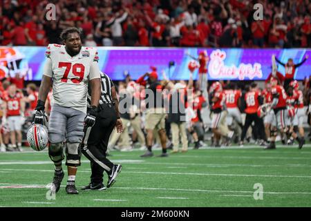 Atlanta, Georgia, USA. 1. Januar 2023. Ohio State Buckeyes Offensive Lineman Dawand Jones (79) verlässt das Spielfeld, während Georgia Bulldog-Spieler nach dem Verlust des Chick-fil-A Peach Bowl im Mercedes Benz Stadium, Atlanta, Georgia, feiern. (Kreditbild: © Scott Stuart/ZUMA Press Wire) Kredit: ZUMA Press, Inc./Alamy Live News Stockfoto