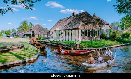 GIETHOORN, NIEDERLANDE Mai 2020 typische Häuser und Touristen in bunten Elektrobooten in Giethoorn, Niederlande. Die wunderschönen Häuser und die Gartenstadt sind in Europa als Venedig des Nordens bekannt Stockfoto