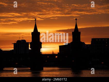 Berlin, Deutschland. 01. Januar 2023. Die Sonne geht hinter der Oberbaumbrücke auf. Kredit: Paul Zinken/dpa/Alamy Live News Stockfoto