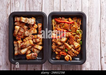 Gebratenes Schweinefleisch und scharfes Schweinefleisch in Behältern Stockfoto