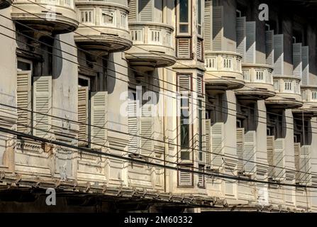 Wunderschönes symmetrisches Fensterdesign eines alten Gebäudes mit Texturen und Mustern. Stockfoto