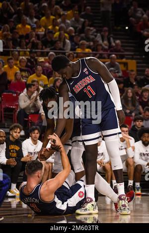 Der Wachmann der University of Arizona Adama Bal (2) und das Zentrum Oumar Ballo (11) helfen, Pelle Larsson (3) nach einem harten Sturz in der ersten Hälfte der NCAA zu schützen Stockfoto