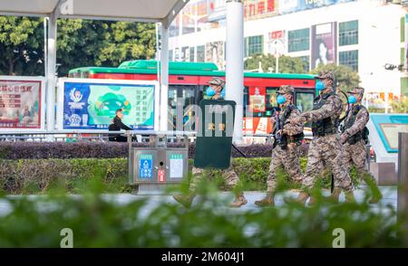 BEIHAI, CHINA - 1. JANUAR 2023 - bewaffnete Polizeibeamte und Soldaten patrouillieren auf einem Platz in der Innenstadt von Beihai, dem südchinesischen Autonomen Guangxi Zhuang Stockfoto