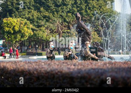 BEIHAI, CHINA - 1. JANUAR 2023 - bewaffnete Polizeibeamte und Soldaten patrouillieren auf einem Platz in der Innenstadt von Beihai, dem südchinesischen Autonomen Guangxi Zhuang Stockfoto