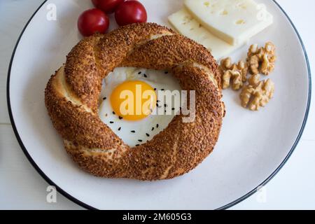Köstlicher Frühstücksteller, Frühstückspräsentation bestehend aus Bagels, Eiern, Käse, Walnüssen und Tomaten. Stockfoto