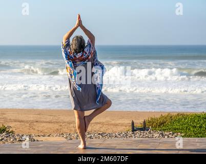 Frau, die Yoga vorführt Baum Pose Vrikshasanayoga, Atlantischer Ozean Marokko, Nordafrika Stockfoto