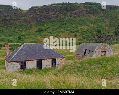 Einer der aus Backstein gebauten Lachs-Bothies mit Equipment and Ice House daneben hinter den Dünen von St. Cyrus Beach in Aberdeenshire. Stockfoto