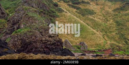 Ein altes, lange verlassenes Fishermans Cottage, versteckt unter den Klippen neben dem Kieselstrand am nördlichen Ende von St. Cyrus. Stockfoto