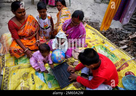 Konserven, Indien. 31. Dezember 2022. Kleine Kinder nutzen Laptop und einen Globus mit ihren Familienmitgliedern im Dorf Canning. Der Begriff „technologische Revolution“ erfasst Erklärungen technologischer Veränderungen und ihrer Auswirkungen auf das menschliche Leben. Mit der Entwicklung des technischen Fortschritts, insbesondere des Internet und mobiler Geräte (Smartphones, Tablet-Computer, Laptops usw.) Haben die Lebensweise der Menschen radikal verändert. (Foto: Avishek das/SOPA Images/Sipa USA) Guthaben: SIPA USA/Alamy Live News Stockfoto