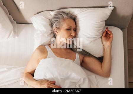 Der große Winkel einer Seniorin, die in ihrem Bett schläft Stockfoto