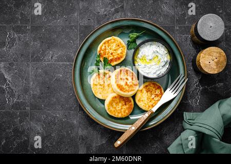 Hüttenkäse-Pommes mit griechischem Joghurt Tzatziki Sauce, Draufsicht Stockfoto