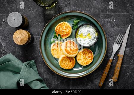 Hüttenkäse-Pommes mit griechischem Joghurt Tzatziki Sauce, Draufsicht Stockfoto