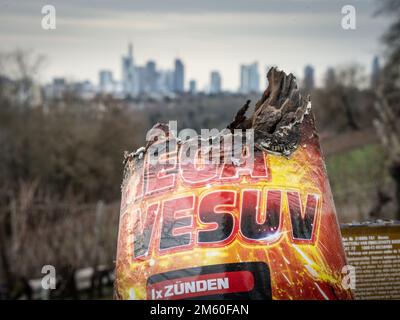 01. Januar 2023, Hessen, Frankfurt/Main: Am Neujahrstag steht an einer Mauer auf dem Frankfurter Lohrberg ein ausgebranntes Feuerwerk namens „Mega Vesuv“, während die Banktürme der Stadt dahinter zu sehen sind. Foto: Frank Rumpenhorst/dpa Stockfoto