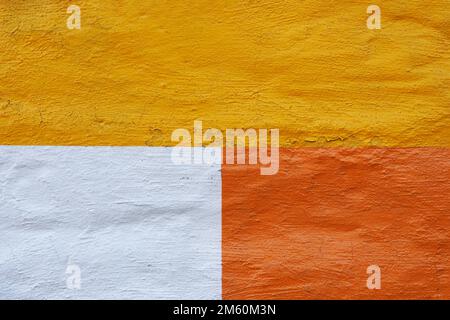 Strukturierter Wandhintergrund, gelb, weiß und orange gestrichen Stockfoto
