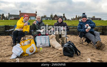 North Berwick, East Lothian, Schottland, Vereinigtes Königreich, 1. Januar 2023, Loony Dook: Zwei Familien aus Carluke und Whitburn treffen sich am Strand in West Bay, um den Loony Dook vor der Veranstaltung zu genießen und ein Picknick zu machen. Credit Sally Anderson/Alamy Live News Stockfoto