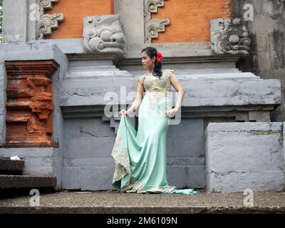 Porträt einer balinesischen Frau in traditioneller balinesischer Mode mit Blumendekorationen auf ihrem Haar Stockfoto