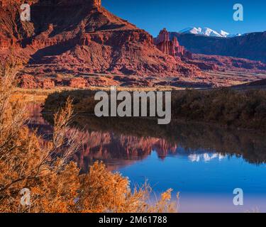 Unberührte Reflexion der Fishers Towers und der schneebedeckten La Sal Berge im Colorado River bei Moab, Utah Stockfoto