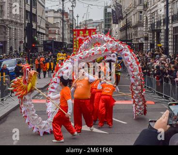 London, Großbritannien. 1. Januar 2023 Die Teilnehmer treten mit einem chinesischen Drachen auf der Londoner Neujahrsparade in Piccadilly auf. LNYDP ist eine jährliche Parade durch die Straßen des Londoner West End. Kredit: Vuk Valcic/Alamy Live News Stockfoto