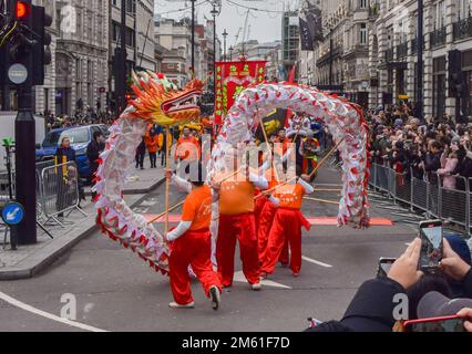 London, Großbritannien. 1. Januar 2023 Die Teilnehmer treten mit einem chinesischen Drachen auf der Londoner Neujahrsparade in Piccadilly auf. LNYDP ist eine jährliche Parade durch die Straßen des Londoner West End. Kredit: Vuk Valcic/Alamy Live News Stockfoto