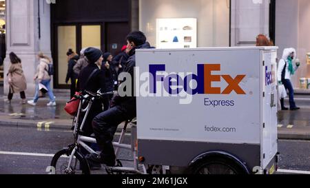 FedEx-Lieferer auf einem Fahrrad - LONDON, Großbritannien - 20. DEZEMBER 2022 Stockfoto