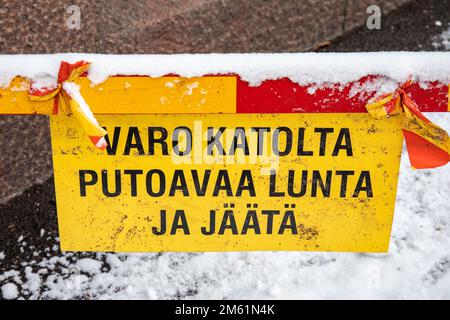 Varo katolta putoavaa lunta ja jäästi. Vorsicht vor herabfallendem Schnee und Eis. Gelbes Warnschild in Helsinki, Finnland. Stockfoto