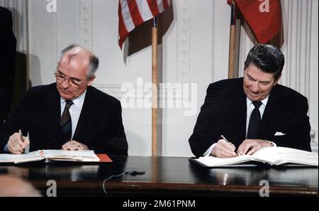 USA Präsident Ronald Reagan und der sowjetische Generalsekretär Michail Gorbatschow unterzeichneten den INF-Vertrag im Ostzimmer des Weißen Hauses im Jahr 1987. Der Intermediate-Range Nuclear Forces Treaty (INF) ist ein Abkommen von 1987 zwischen den Vereinigten Staaten und der Sowjetunion. Durch den Vertrag wurden nukleare und konventionelle ballistische Raketen und Marschflugkörper mit mittlerer Reichweite abgeschafft. Foto Vom Weißen Haus. Stockfoto