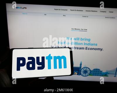 Person, die ein Smartphone mit dem Logo des indischen Unternehmens für digitale Zahlungen Paytm auf dem Bildschirm vor der Website hält. Konzentrieren Sie sich auf das Display des Telefons. Stockfoto