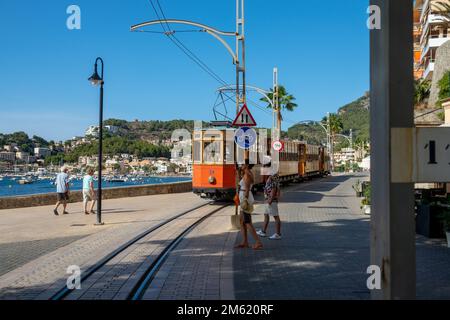 Soller, Spanien; 27. August 2022: Beliebter Soller-Zug auf Mallorca (Spanien), der an einem sonnigen Sommertag durch den Hafen von Soller fährt Stockfoto