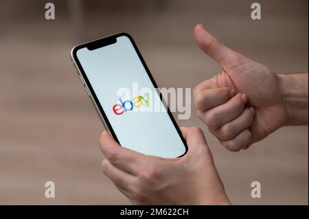 3. Dezember 2022, Almaty, Kasachstan: Eine Frau hält ein Smartphone mit einer Ebay-Anwendung und zeigt Daumen nach oben. Stockfoto