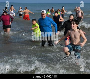 Racine, Wisconsin, USA. 1. Januar 2023. Die Temperaturen waren relativ mild für den 30. Jährlichen Splash and Dash Polar Sprung in Lake Michigan in Racine, Wisconsin Sonntag, den 1. Januar 2023. Die Lufttemperatur lag bei den niedrigen 40s Grad und die Wassertemperatur bei 36,9 Grad. Viele Jahre gibt es Eisplatten auf dem Sand von North Beach, die zum Wasser führen. Die Veranstaltung kommt mehreren lokalen Wohltätigkeitsorganisationen zugute. Kredit: ZUMA Press, Inc./Alamy Live News Stockfoto