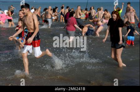 Racine, Wisconsin, USA. 1. Januar 2023. Die Temperaturen waren relativ mild für den 30. Jährlichen Splash and Dash Polar Sprung in Lake Michigan in Racine, Wisconsin Sonntag, den 1. Januar 2023. Die Lufttemperatur lag bei den niedrigen 40s Grad und die Wassertemperatur bei 36,9 Grad. Viele Jahre gibt es Eisplatten auf dem Sand von North Beach, die zum Wasser führen. Die Veranstaltung kommt mehreren lokalen Wohltätigkeitsorganisationen zugute. Kredit: ZUMA Press, Inc./Alamy Live News Stockfoto