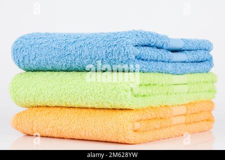 Set aus drei Handtüchern in verschiedenen Farben; Foto auf weißem Hintergrund. Stockfoto