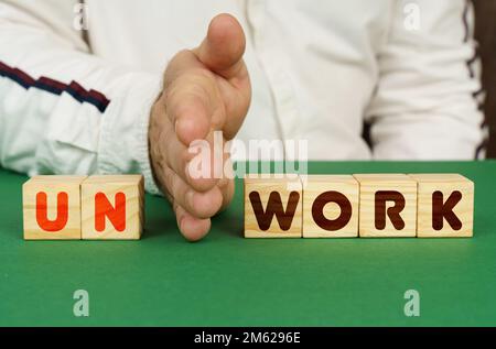 Geschäftskonzept. Ein Mann trennt die Würfel mit der Aufschrift "UNWORK" oder "WORK" Stockfoto