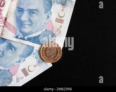 Auf diesem Foto wurden türkische Banknoten von 100 Lira mit einem Porträt von Mustafa Atatürk und einer Münze von 1 Lira gezeigt. Stockfoto