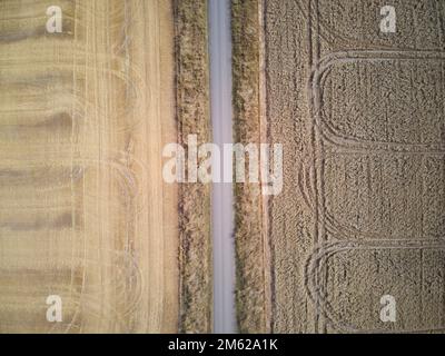 Landstraße aus der Vogelperspektive mit Weizenfeldmustern und Spuren der Ernte. Victoria, Australien. Stockfoto