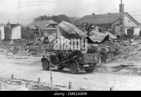 Deutsche Soldaten und ein Jeep in den Ruinen einer unbekannten sowjetischen Stadt. Foto während der Operation Barbarossa, der nazi-Invasion der Sowjetunion Stockfoto