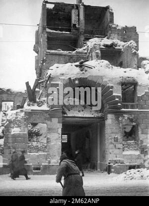 Eingangstor zu einem zerstörten Gebäude in warschau, Polen. Die Quelle nennt das Datum 1939, die Menschen tragen Mäntel, was darauf hindeutet, dass das Bild aus dem späten 1939 nach der deutschen Invasion und polnischen Kapitulation stammt Stockfoto