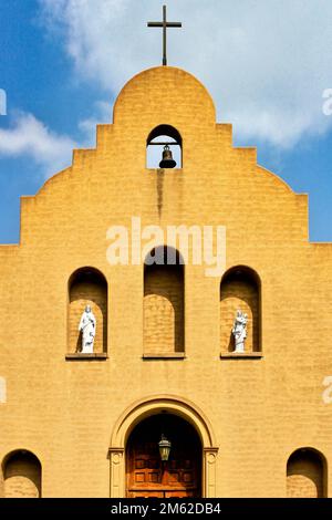 Die Fassade der katholischen Mission Good Shepherd in Marietta Oklahoma umfasst ein Kreuz, eine Glocke und religiöse Statuen. Stockfoto