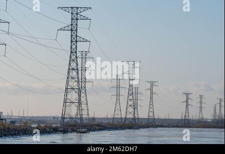 Städtische Stromleitungen mit industriellem Hintergrund Stockfoto