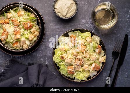 Lebensmittelfotografie mit caesar Salat, Huhn, Eisberg, Salat, Parmesan, Croutons, Soße Stockfoto