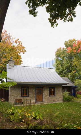 Alt um 1850 Jahre Landhausstil Feldsteinfassade mit blauer Verzierung im Herbst. Stockfoto