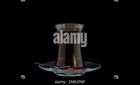 Ein Glas türkischen und arabischen Tee mit einer Tasse Kaffee auf einem schwarzen background.indispensable im ramadan Stockfoto