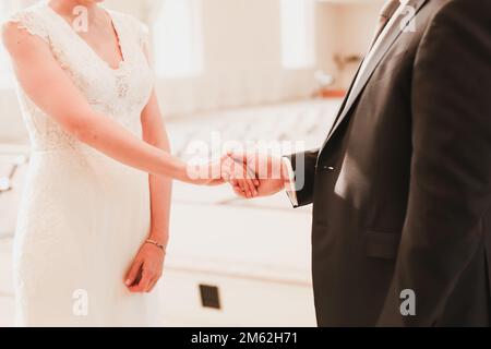 Hochzeitshände und -Ringe Braut und Bräutigam Verlobungssitzung Hochzeitsfeier Händchenhalten während der Zeremonie Stockfoto