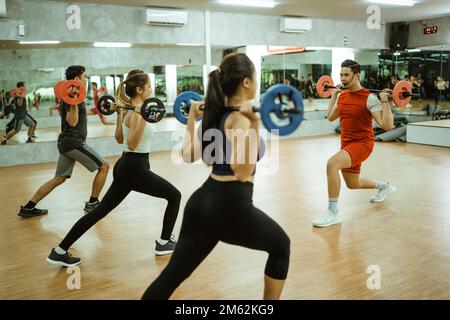 Der männliche Ausbilder gab ein Exempel bei Barbell Back Squats Stockfoto