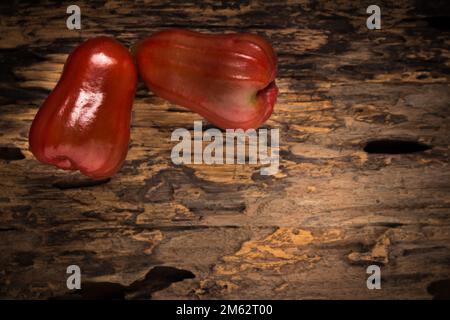 Rosenapfel auf Holz. Dunkel. Nacht. Stockfoto