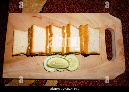 Frisch gebackenes Ciabatta-Brot. Nahaufnahme von geschnittenem Getreidebrot auf braunem Holztablett Stockfoto