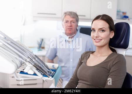 Ziemlich geduldig beim Zahnarzt. Porträt eines hübschen jungen Patienten, der mit einem Zahnarzt in der Klinik lächelt. Stockfoto